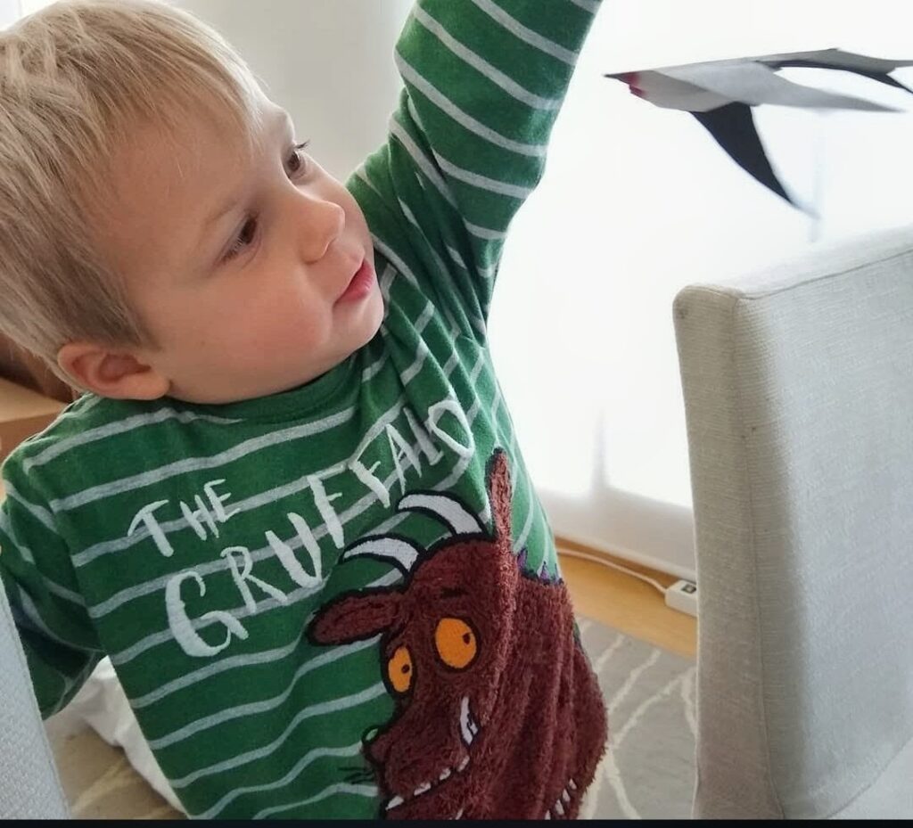 How to Help Your Firstborn Adjust to a New Baby - older sibling holding finished Montessori mobile