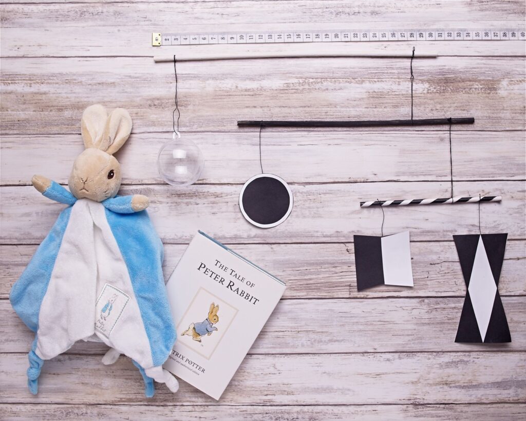Close-up of the Montessori Munari mobile showing black-and-white geometric shapes and the clear sphere that support newborn visual focus.