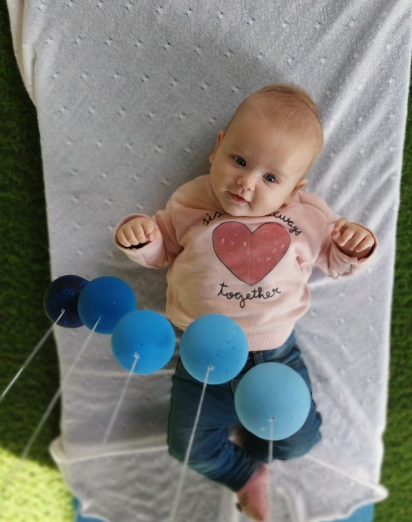 A baby focusing the highest ball of the Gobbi 