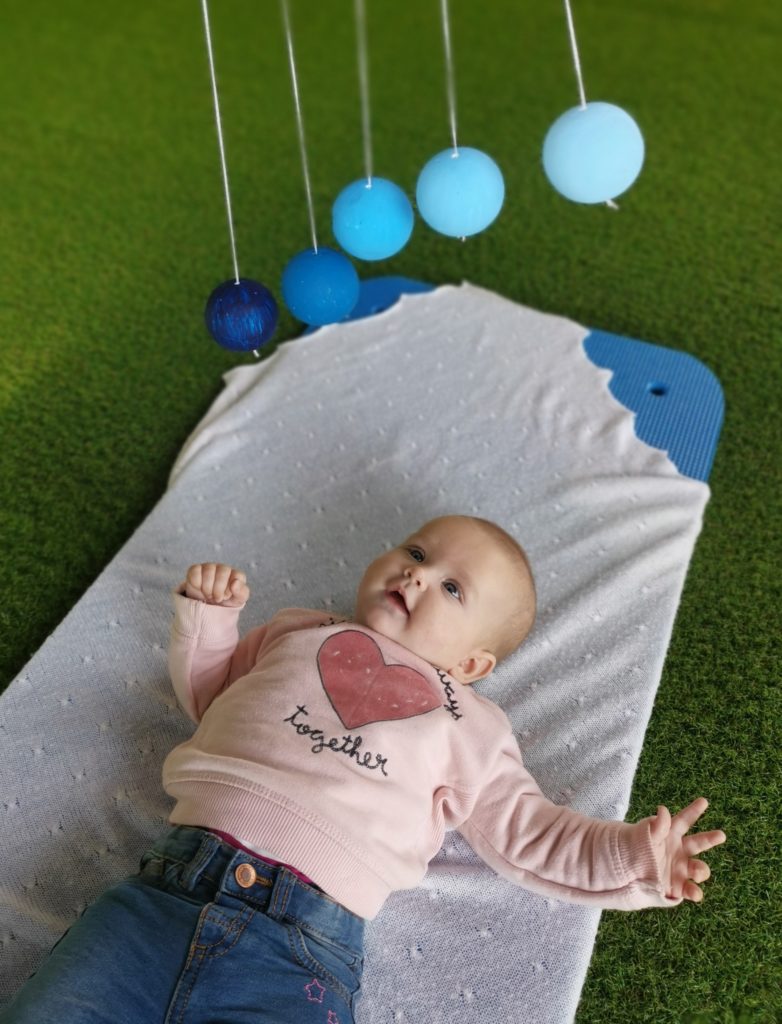Baby observing a Gobbi mobile with sustained visual focus