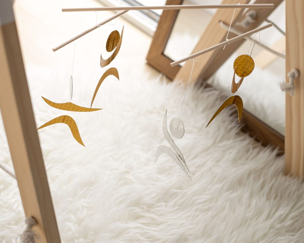 Móvil Montessori de los Bailarines suspendido en un soporte, con figuras moviéndose a distintas alturas.