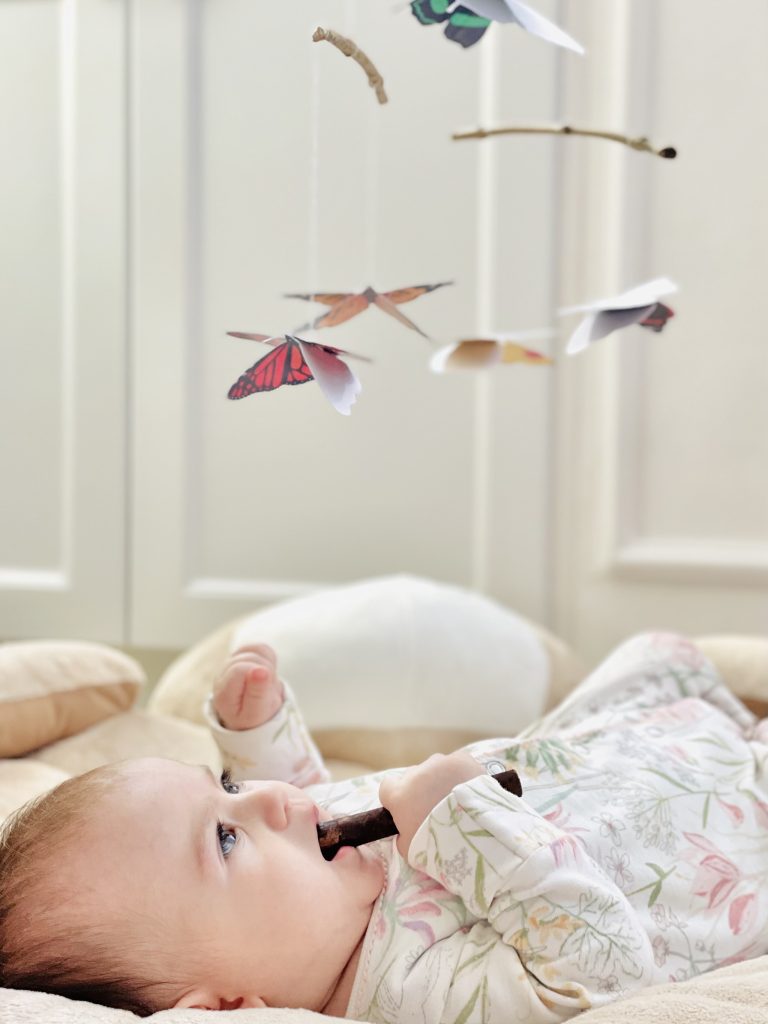 Bebé niña con el móvil Montessori DIY Las Mariposas
