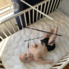 Hanging Montessori visual mobiles - a baby is observing a mobile in his cot.