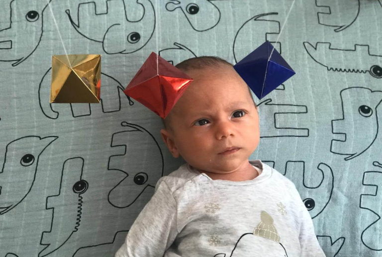 Baby is observing the Montessori Octahedron mobile