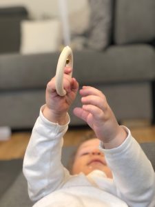 A baby is pulling the Ring on a Ribbon mobile - Montessori Observation