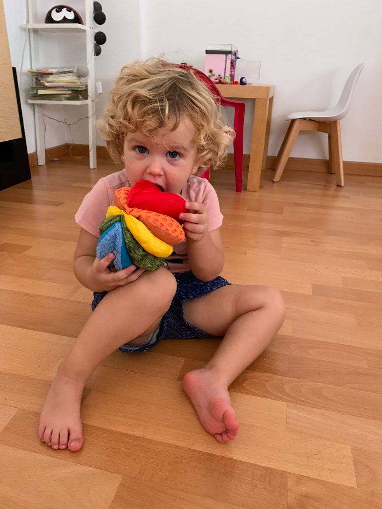 Una niña jugando con la Pelota Sensorial de Tela