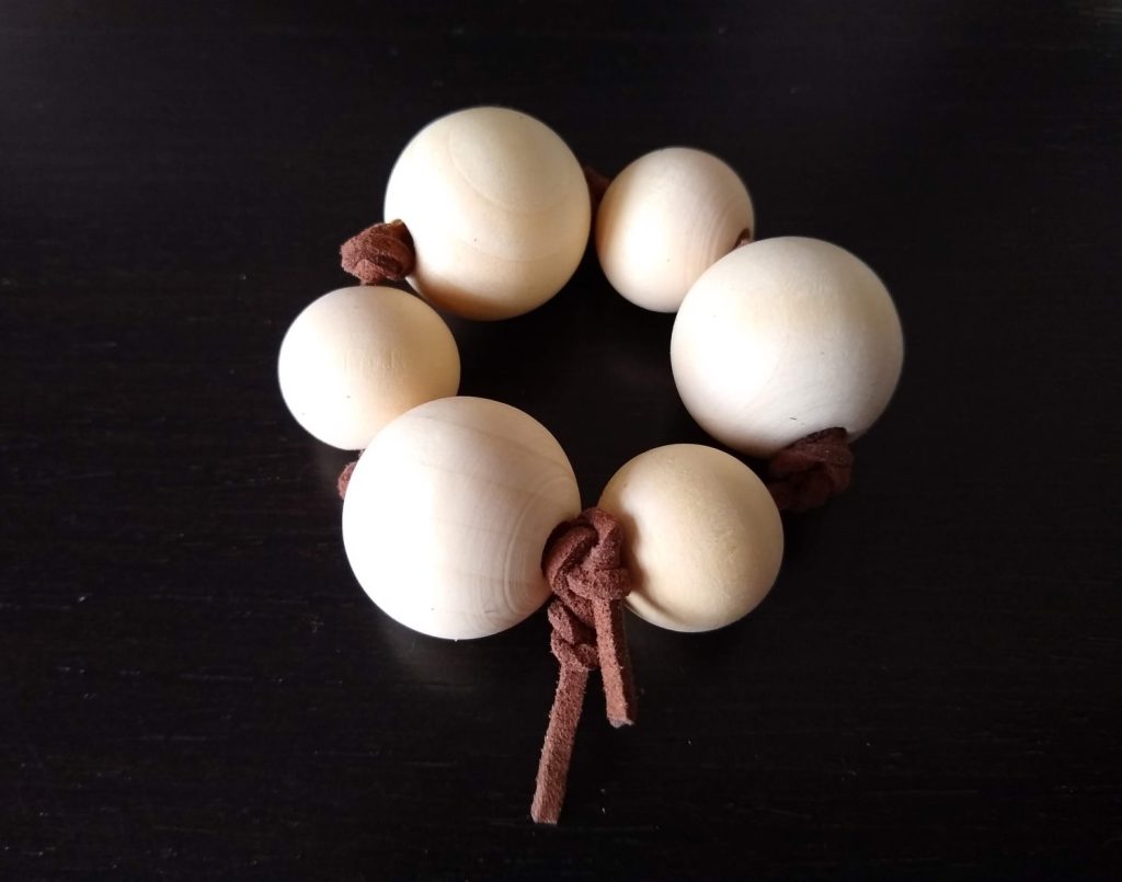 The Montessori Grasping Beads tied together to form a sensory bracelet. cuentas de agarre Montessori en forma de pulsera