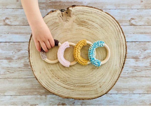 A boy is reaching for a crochet teething ring