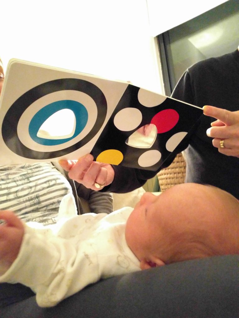 Az egyhónapos babám fekete-fehér babakönyvet olvas