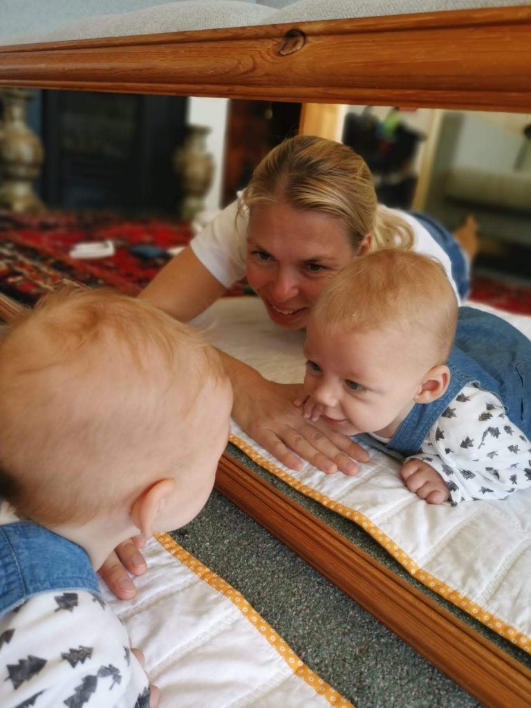 Hasonfekvés - I'm lying in front of a mirror with a baby, looking at each other in the mirror while doing tummy time.