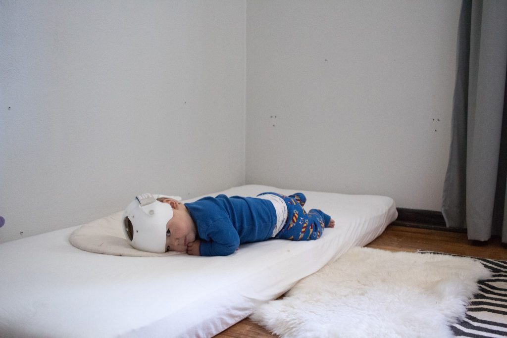 The Montessori floor bed with a baby lying on it. Montessori ágy, la cama Montessori