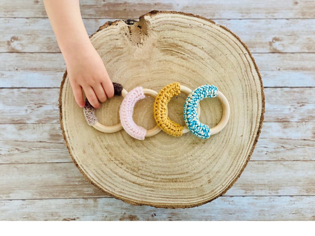 bebé con anillo de dentición de madera y crochet