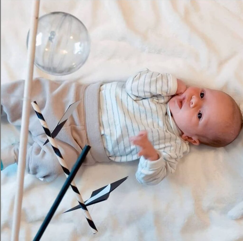 Baby lying under the Montessori Munari baby mobile